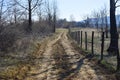 Forgoten country road with barbed wire fence in a beautiful sunny spring day Royalty Free Stock Photo