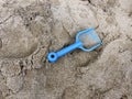 Forgotten children's toy shovel in the sand in the sandbox