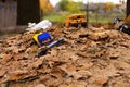 Forgotten children`s toys on a pile of sand under the autumn foliage