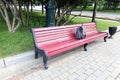 Forgotten gray backpack on a red bench in the park