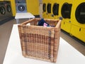 A forgotten wicker basket with clothes in an empty, public laundry room Royalty Free Stock Photo