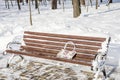 A forgotten woman`s bag on an old bench in the park in the winter Royalty Free Stock Photo