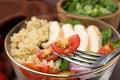 Fork with cherry tomato over bowl of delicious quinoa salad, closeup Royalty Free Stock Photo