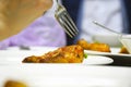 A fork in a chicken leg on a plate Royalty Free Stock Photo