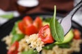 Fork with delicious quinoa salad, closeup view