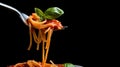A fork full of spaghetti with tomato sauce and basil leaves, isolated on black background Royalty Free Stock Photo