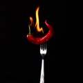 Fork impale to red hot chili on black Royalty Free Stock Photo