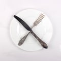 Fork, knife and dinner plate on white Royalty Free Stock Photo