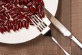 Fork and knife with lots of capsules on dish concept of over-relying on medicine