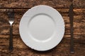 Fork and knife lying near empty white plate Royalty Free Stock Photo
