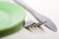 Fork and knife near green plate Royalty Free Stock Photo