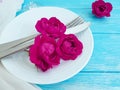 Fork, knife, plate, flower rose anniversary festive concept dating on a blue wooden background, romantic design