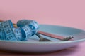 Fork, knife, plate measuring tape on a colored background Royalty Free Stock Photo