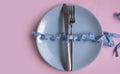 Fork, knife, plate measuring tape  dieting  on a colored background Royalty Free Stock Photo