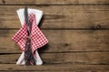 Fork and knife set with red white checked napkin on old rustic w Royalty Free Stock Photo
