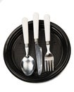 Fork, knife and spoon on a black plastic plate Royalty Free Stock Photo