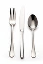A sleek cutlery set featuring a fork, knife, and spoon arranged for dining on a white background Royalty Free Stock Photo