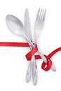 Fork, knife and spoon tied with red ribbon isolated Royalty Free Stock Photo