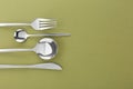 Fork, knife and spoons on green background, flat lay with space for text. Stylish cutlery set Royalty Free Stock Photo