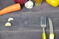 Fork and knife on the table, with vegetables, spices, olive oil and sauce, ketchup. Table ready to eat. carrots, garlic Royalty Free Stock Photo