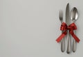 Fork and knife tied with a red ribbon isolated in the corner on white background with copy space Royalty Free Stock Photo