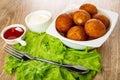 Fork on lettuce, sauceboat with ketchup, bowl with mayonnaise, bowl with fried pies on wooden table Royalty Free Stock Photo