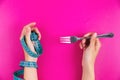 Fork and measuring tape in hand on a bright pink background. Woman with hand tied with measuring tape, holding a fork Royalty Free Stock Photo