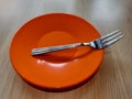 a fork on an orange cake plate.