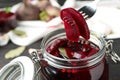 Fork with pickled beets over glass jar on table, closeup