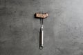 Fork with piece of delicious barbecued meat on gray background