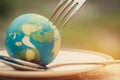 Fork slammed on Globe model placed on plate for serve menu in famous hotel. International cuisine is practiced around the world