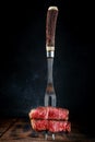 Fork with sliced grilled beef fillet steak on a wooden table Royalty Free Stock Photo