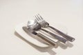 Fork, spoon and butter knife on a white plate Royalty Free Stock Photo