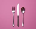 a fork spoon and knife on a pink background Royalty Free Stock Photo