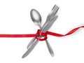 Fork, spoon and knife tied with a red ribbon isolated on white w Royalty Free Stock Photo