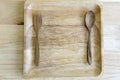 Fork spoon and plate made from wood on wood background