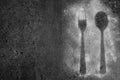 Fork and spoon silhouette on dark background