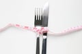 Fork and spoon tied with tape measure - Diet concept on white