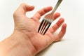 Fork stabbing a hand palm on white background