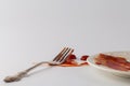 Fork stained tomato ketchup on table with dish