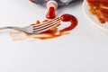 Fork stained tomato ketshup on table with dish