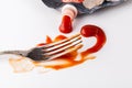 Fork stained tomato ketshup on table with dish