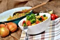 Fork and tuna risotto with vegetables, tomatoes, broccoli and parsley in the bowl, onions, oil and pan in the background Royalty Free Stock Photo