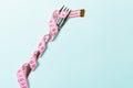 Fork wrapped in measuring tape on blue background. Top view of overeating concept