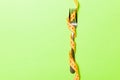 Fork wrapped in measuring tape on green background. Top view of overeating concept