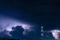 Forked lightning over the cell phone antenna tower at night Royalty Free Stock Photo