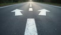 Forked road with white arrows points in different directions. Concept of choice. Sign on asphalt road dividing transport stream. Royalty Free Stock Photo