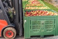 Forklift carries crates of fruit. Many apples in container