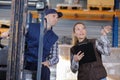 forklift driver and female supervisor with clipboard Royalty Free Stock Photo