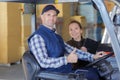 Forklift driver and female supervisor with clipboard at warehouse Royalty Free Stock Photo